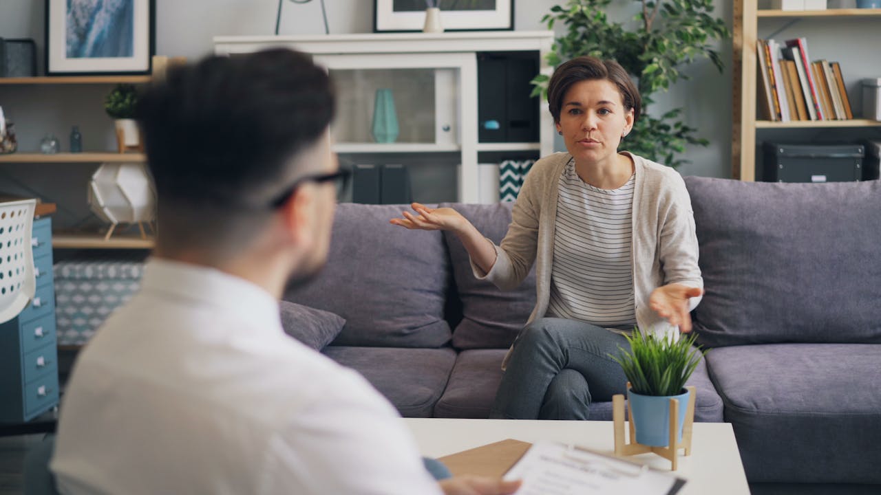 A woman consulting with a professional therapist in a modern office setting.